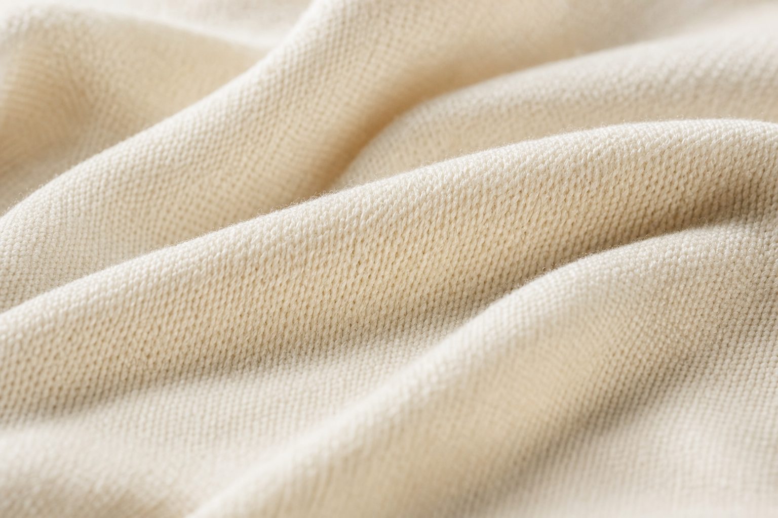 Close-up of soft ivory bamboo knit fabric falling in gentle folds